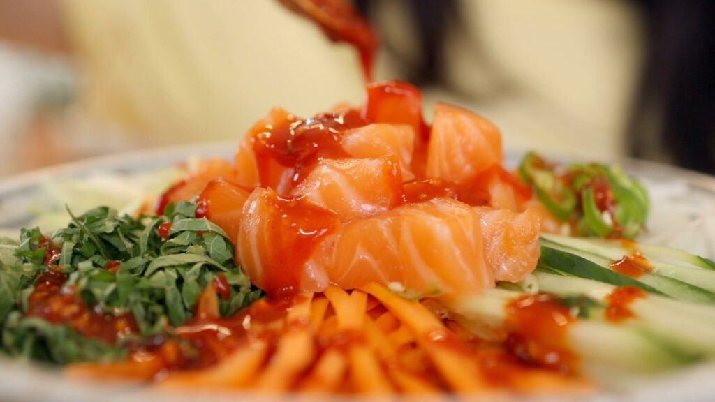 Drizzle gochujang sauce over hoedeopbap (sashimi rice bowl)