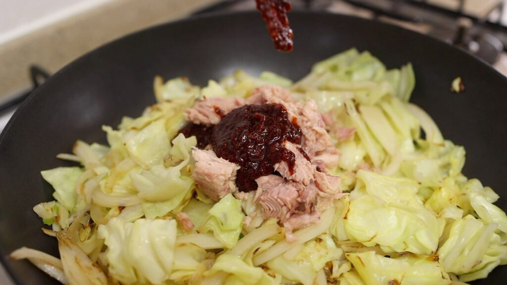 Cook cabbage and tuna in a pan
