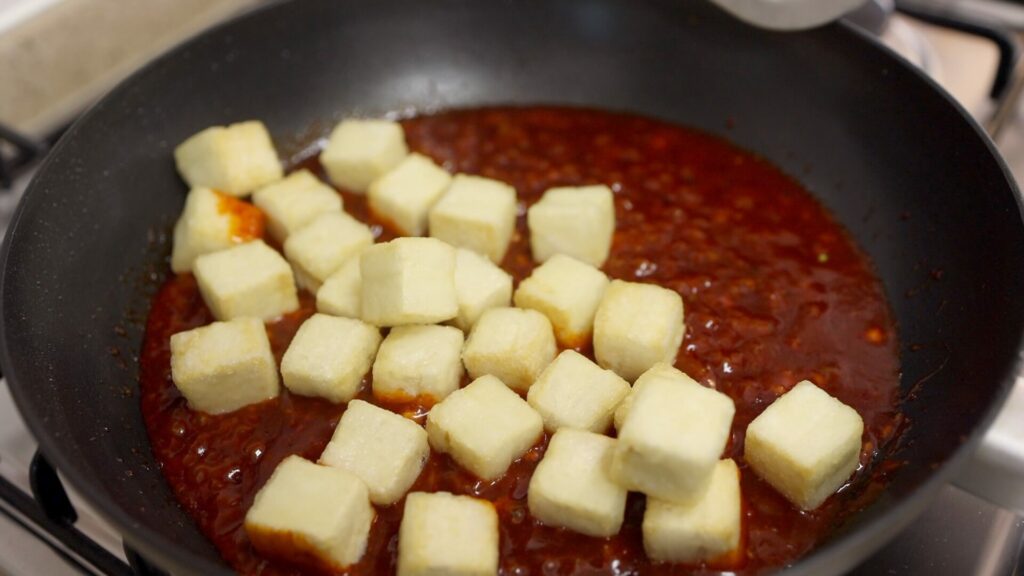 Coat the fried tofu with gochujang sauce