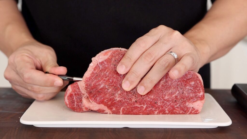 Inserting a thermometer into the steak